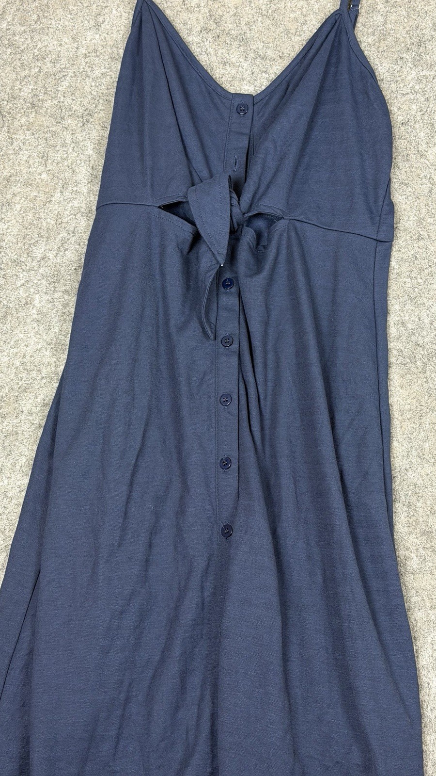 Navy midi dress features a tie-front detail and spaghetti straps.